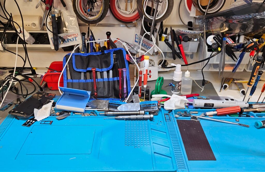 Professionele telefoonreparatie op een werkbank met gereedschap